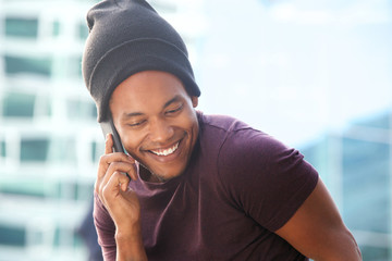 Fototapeta premium happy african american guy talking with cellphone in city