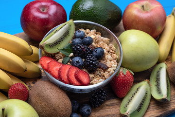 Close-up of bright assorted fruits, bananas, apples, mangoes, kiwi, strawberries, blueberries