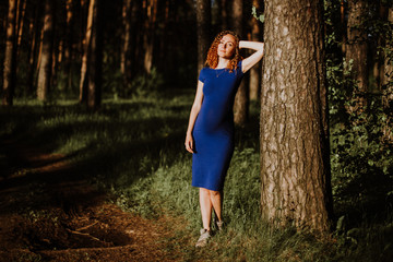 warm evening sun gently illuminates a beautiful girl walking through the woods