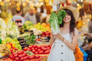 Woman is chooses  fruits and vegetables at food market. Reusable eco bag for shopping. Zero waste...