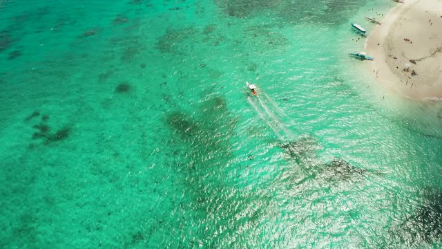 Motor boat on the surface of the lagoon with turquoise water, top view. Summer and travel vacation concept.