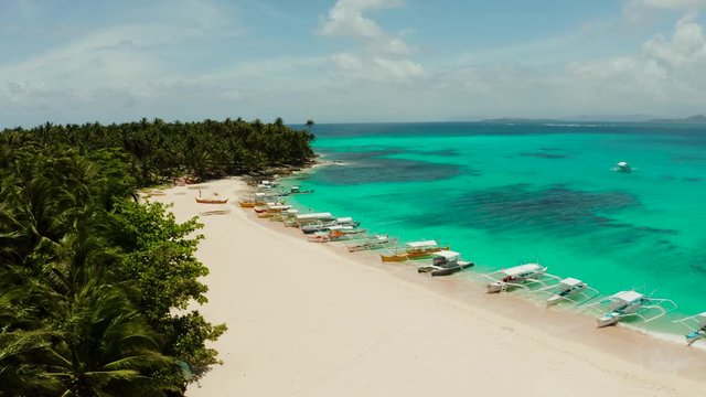 Tropical island with beautiful beach, palm trees and turquoise water view from above. Daco island, Philippines. Summer and travel vacation concept