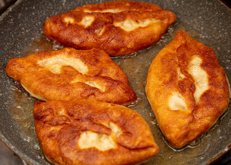 Patties are fried in oil in a pan
