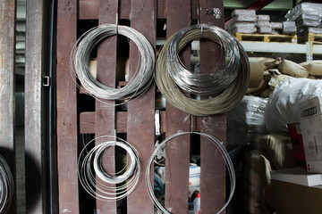 some coils of fechral thick refractory wire hangs in a warehouse of goods for ceramists. Frame of...