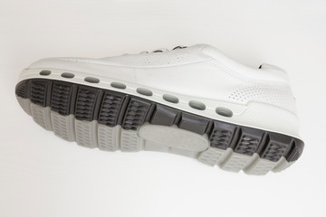 One white sport female sneaker turned. Natural leather wear, waterproof perforated trainer shoe.
