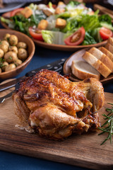 dinning image with whole grilled chicken and salad