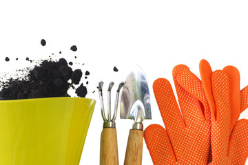 Green pot with spilled soil, orange gloves, a small shovel and a rake. Isolate on white background....