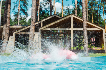 splash near inflatable rings in swimming pool with clean blue water