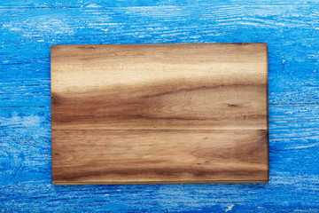Rectangular wooden cutting board made of light wood as a background - space for text. on brown wooden background.