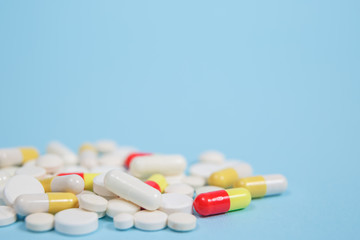 Pills are scattered over a blue background