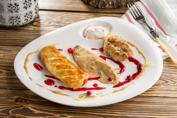 fried fish fillet and pie with mushroom sauce on wooden table