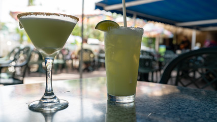 Two chilled tropical cocktails on a bar counter