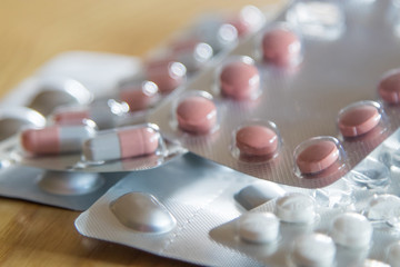 medicine, drugs and pills stacked on wood