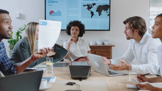 young mixed race business woman executive meeting with colleagues discussing development ideas with brainstorming in busy office boardroom