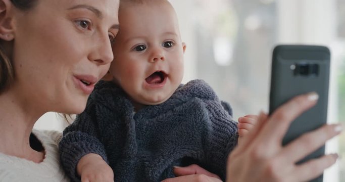 happy mother and baby video chat using smartphone mom holding toddler sharing motherhood lifestyle with friend on social media enjoying mobile technology 4k