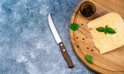 chopped cheese on a kitchen board with basil and pepper
