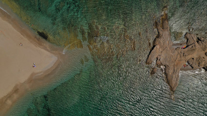 Aerial drone bird's eye view photo of iconic rock volcanic tropical islet with emerald clear water sea