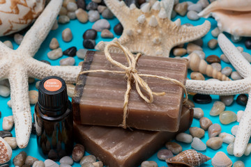 Handmade Frankincense & Myrrh Goat's Milk Bar Soap and Frankincense oil decorated with Pebbles, Sea Stars and Sea Shells on blue background.