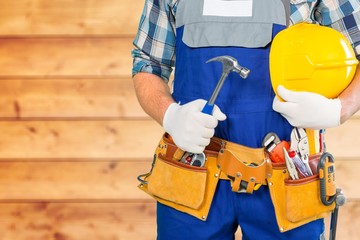 Middle aged male builder with hammer on blurred background