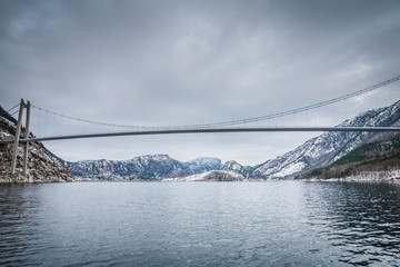 Norwegian Fjord in winter with suspension bridge