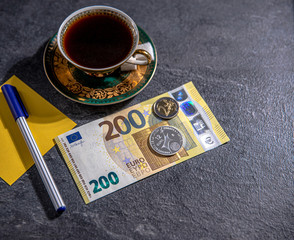 New european one hundred and two hundred Euro notes with Euro coins and crypto currency on the table