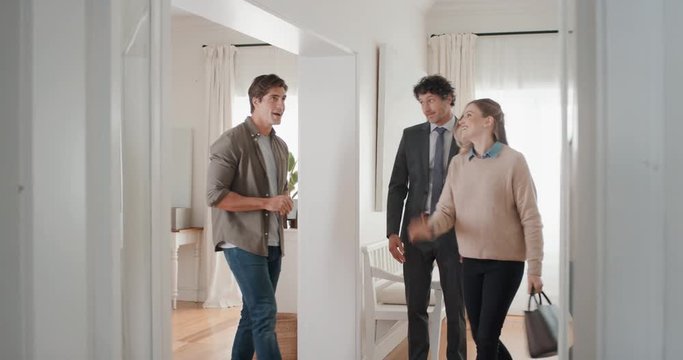 real estate agent showing young couple new house presenting property investment happy clients shaking hands with realtor successfully purchasing home 4k footage