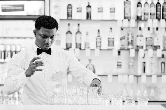 African American Bartender Wear On Bow Tie Cleaning Glasses At Bar.