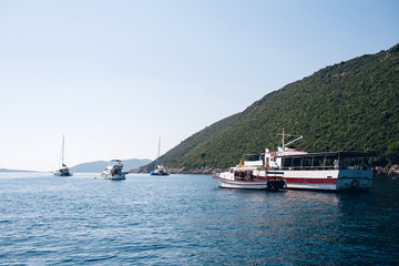 Naklejka premium Seascape of the Adriatic Sea. The sea with mountains and mountains in the background. Boat sailing on the sea. Italy, Montenegro, Adriatic tourism