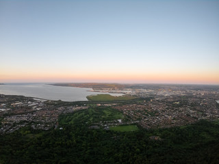 Fototapeta premium Colorful sunset at Cave Hill Country Park Belfast, Northern Ireland. Aerial view on City and hills 