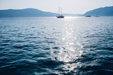 Obraz premium Seascape of the Adriatic Sea. The sea with mountains and mountains in the background. Boat sailing on the sea. Italy, Montenegro, Adriatic tourism