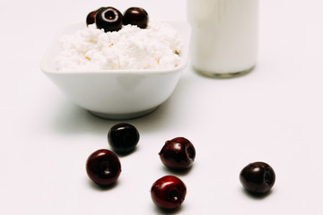 Milk in a bottle cottage cheese and cherry berries on a white background