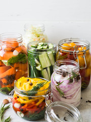 Fototapeta na wymiar Pickled vegetables. Salting various vegetables in glass jars for long-term storage. Preserves vegetables in glass jars. Variety fermented green vegetables on table.