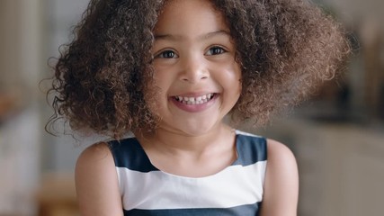 portrait beautiful little mixed race girl smiling looking at camera happy child at home