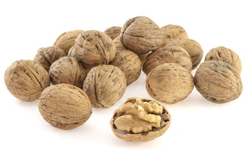 heap of walnuts in shell on white background, close-up