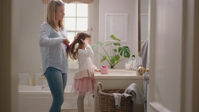 happy mother brushing daughters hair in bathroom cute little girl getting ready in morning loving mom enjoying parenthood caring for child