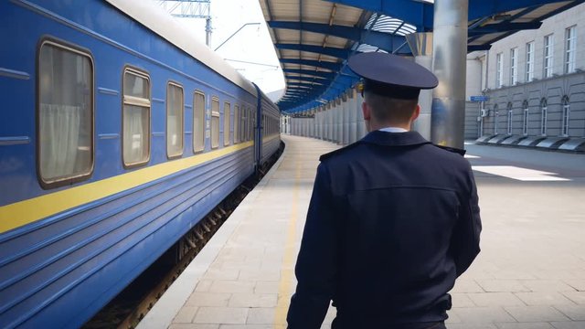 the driver approaches the train along the cars.operator