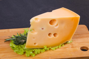 Maasdam cheese  in the board served salad leaves