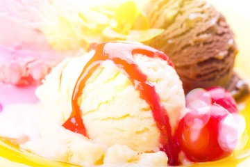 Ice cream scoop  with vanilla, chocolate and berry scoops and topping