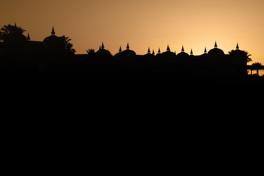 Minarets and domes in backlight at sunrise.