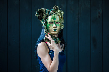 portrait of a woman in a green Venetian masquerade mask on a black background