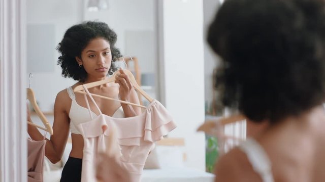 attractive young woman getting dressed looking in mirror choosing outfit putting on clothes enjoying fashion choice positive self image feeling confident at home 4k footage