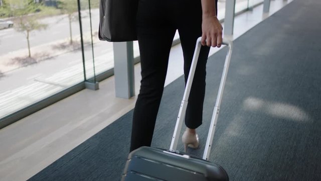 close up legs business woman traveler walking pulling trolly bag in airport female commuter traveling international for business trip 4k