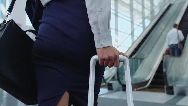 business woman traveler walking in airport with trolly bag going up escalator female executive traveling international for business trip checking messages on smartphone 4k