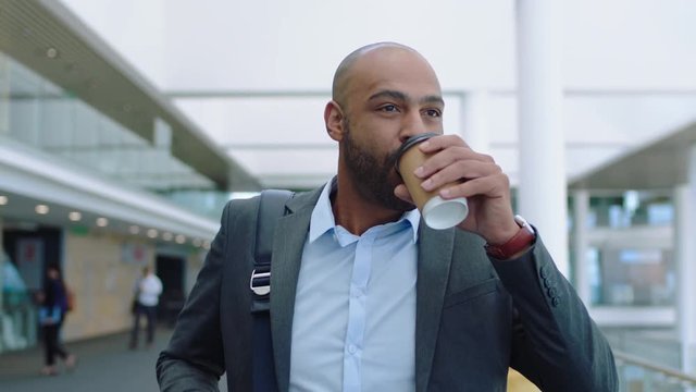 mixed race businessman walking in office lobby drinking coffee enjoying successful career looking confident male executive going to work 4k