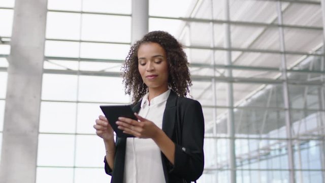 beautiful business woman in airport using tablet computer texting walking in corporate office building checking email messages online successful female executive at work 4k