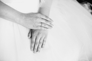 hands of the bride lie on the dress