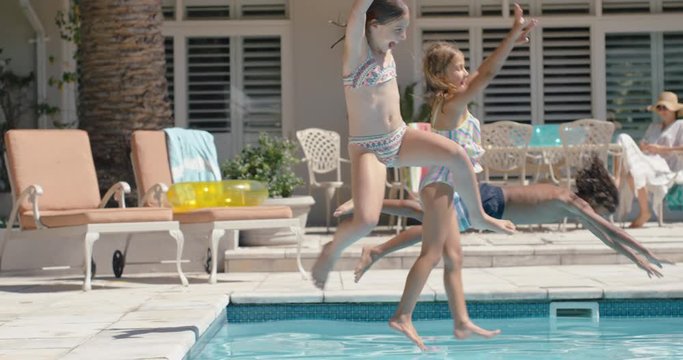happy kids jumping in swimming pool friends splashing playfully having fun together on sunny day enjoying cool water on summer vacation at holiday home 4k