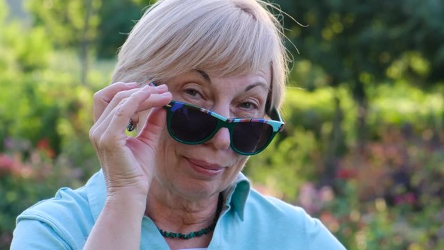 Positive cheerful elderly woman in sunglasses