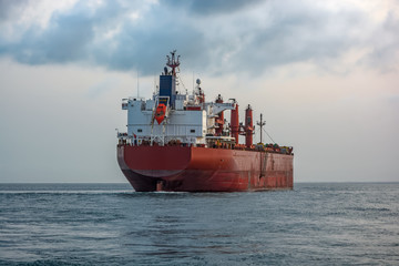 Bulk carrier vessel is awaiting loading of bauxite ore at outer anchorage of Kamsar port, Guinea, West Africa.