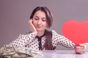 I love money! Beautiful business woman holding heart and cash as symbol of love for US Dollars.